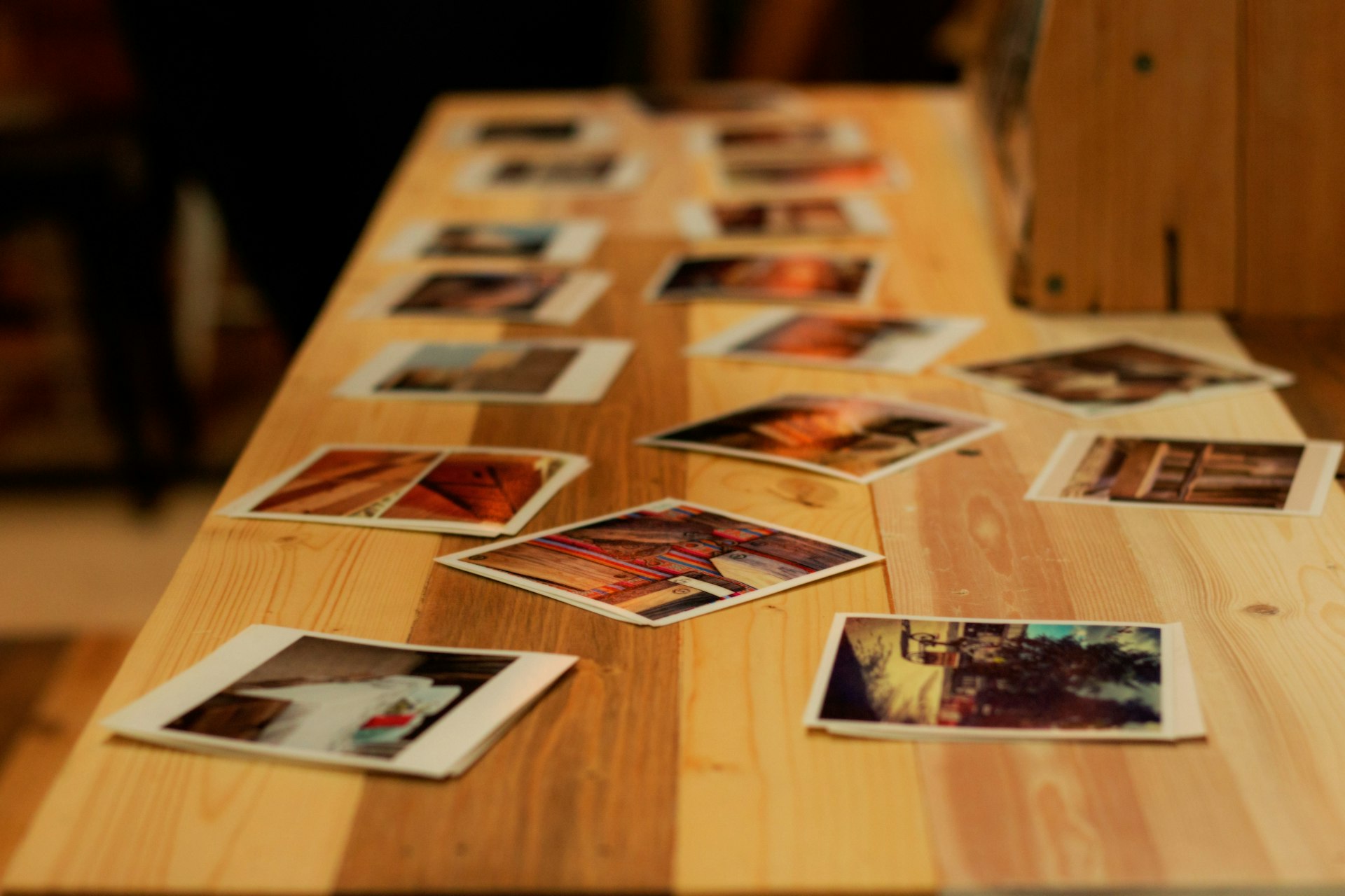 Vintage family photographs scattered on wooden table with soft warm lighting